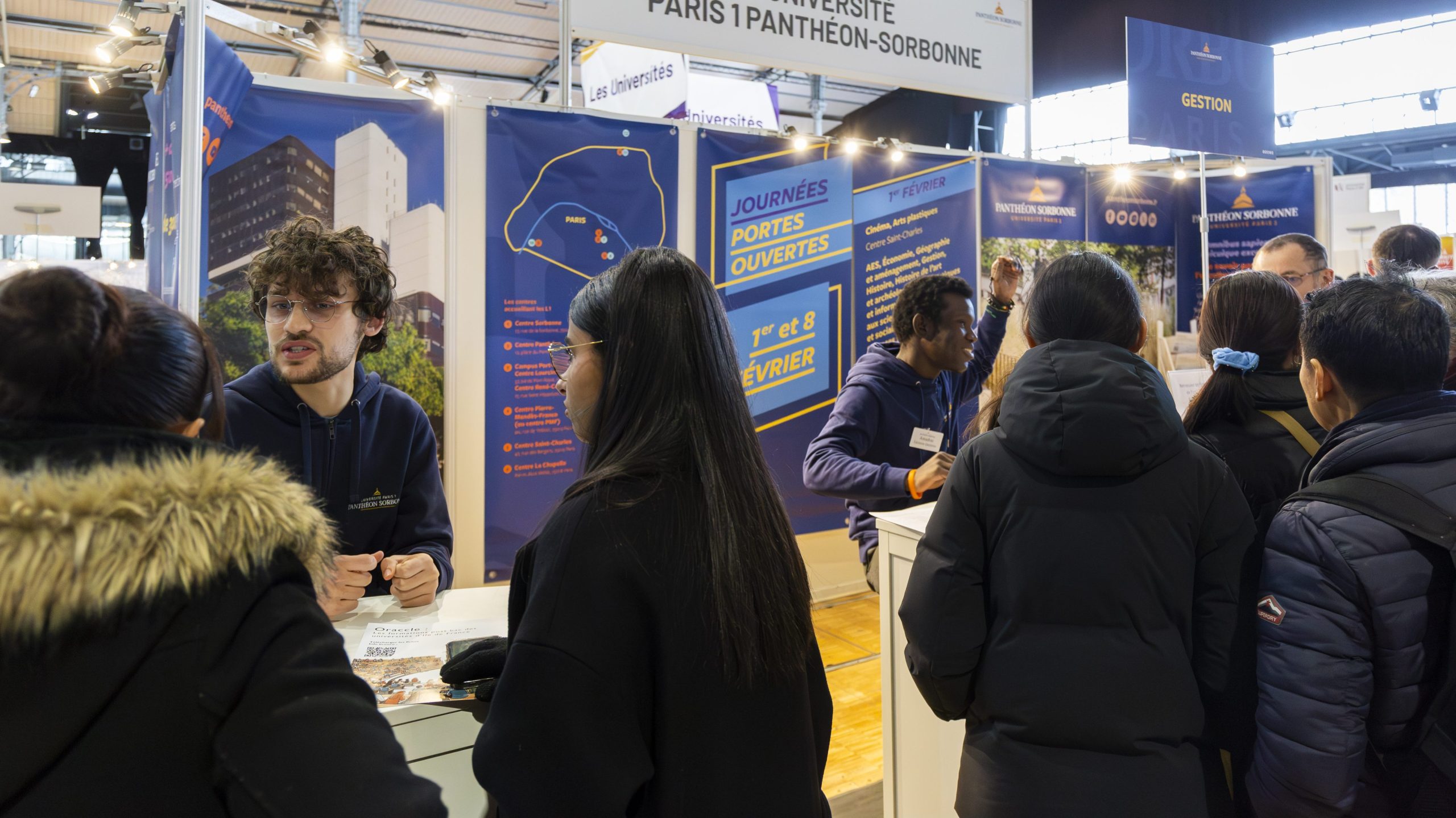 Photo d'exposants discutent avec des visiteurs au salon postbac